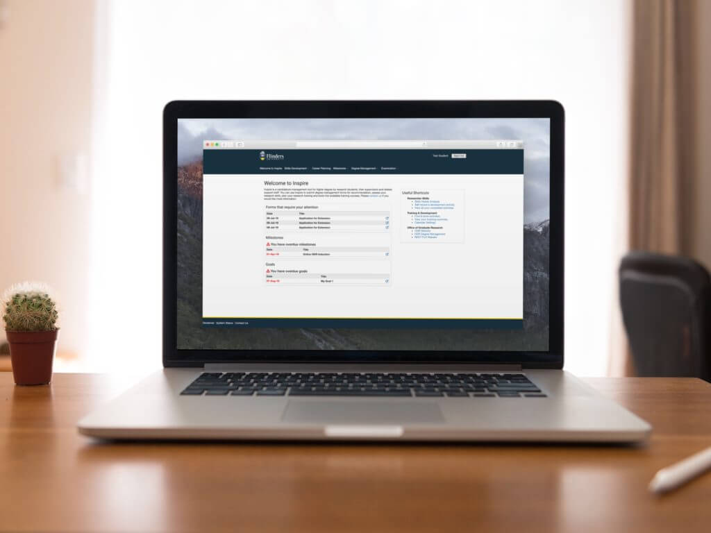 Laptop on a desk showing a screenshot of Flinders University's SkillsForge system, Inspire, on-screen